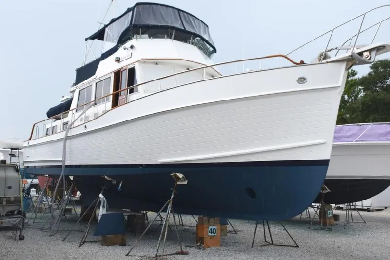 Jamie Lyn Yacht Photos Pics 1997 Grand Banks Classic yacht on stands, white hull with blue bottom, in a boatyard.
