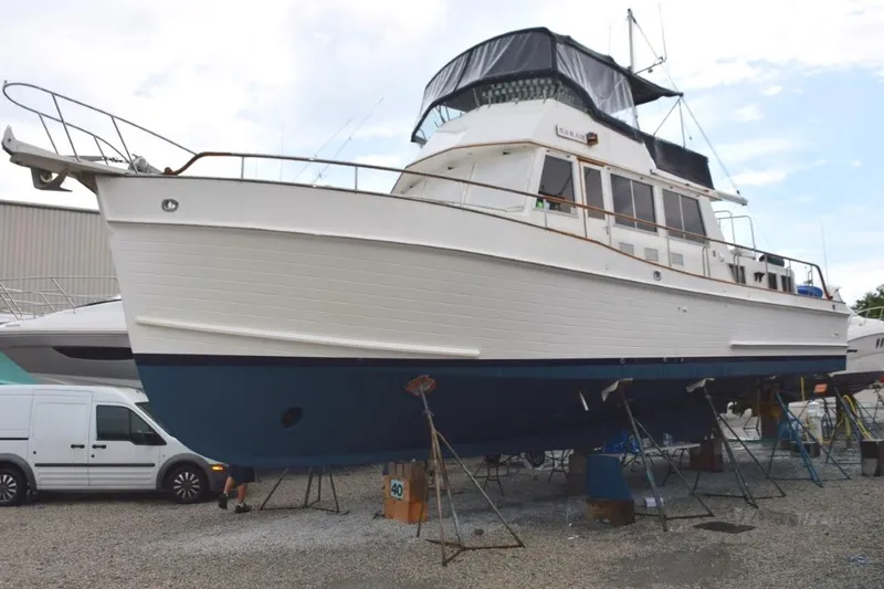 Jamie Lyn Yacht Photos Pics 1997 Grand Banks Classic yacht on dry dock, white hull, blue bottom, covered upper deck.
