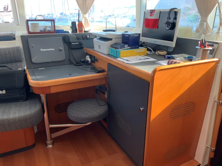 Yacht Photos Pics Navigation station inside a 2007 Lagoon 440 catamaran with Raymarine equipment and office setup.