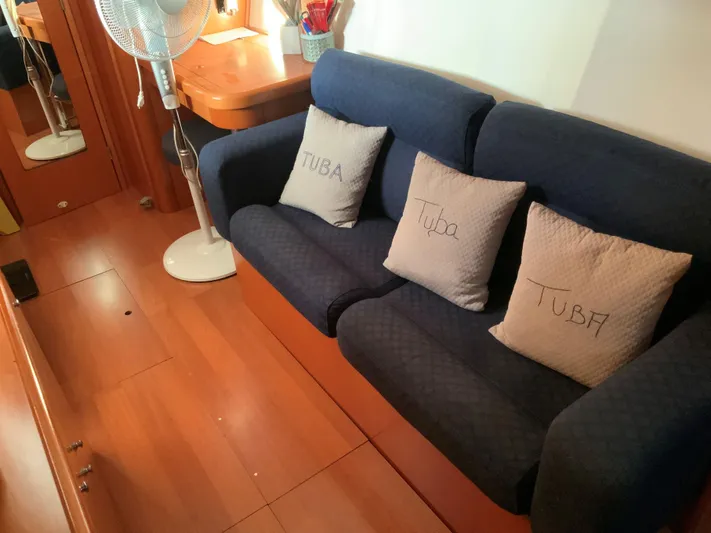  Yacht Photos Pics Interior of 2007 Lagoon 440 yacht with blue sofa, pillows, and wooden flooring.