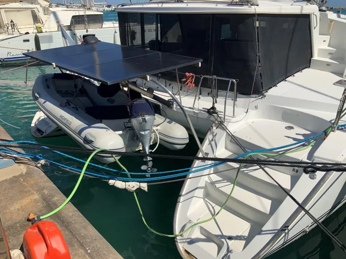  Yacht Photos Pics Lagoon 440 catamaran from 2007 docked with inflatable boat and solar panels.