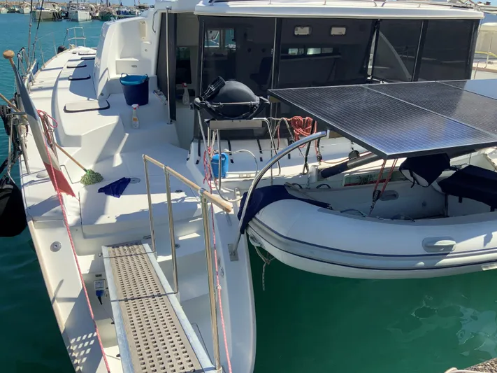  Yacht Photos Pics 2007 Lagoon 440 catamaran with solar panels and dinghy, docked in a marina.
