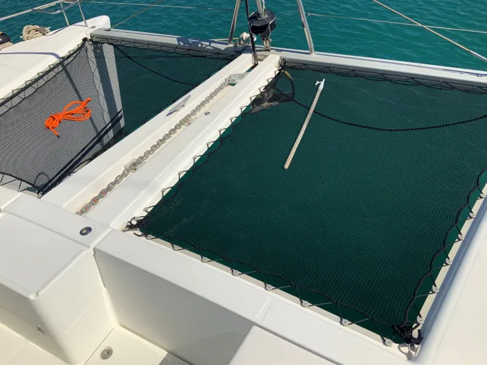  Yacht Photos Pics Catamaran Lagoon 440 (2007) with netting and rope on deck, floating on turquoise water.
