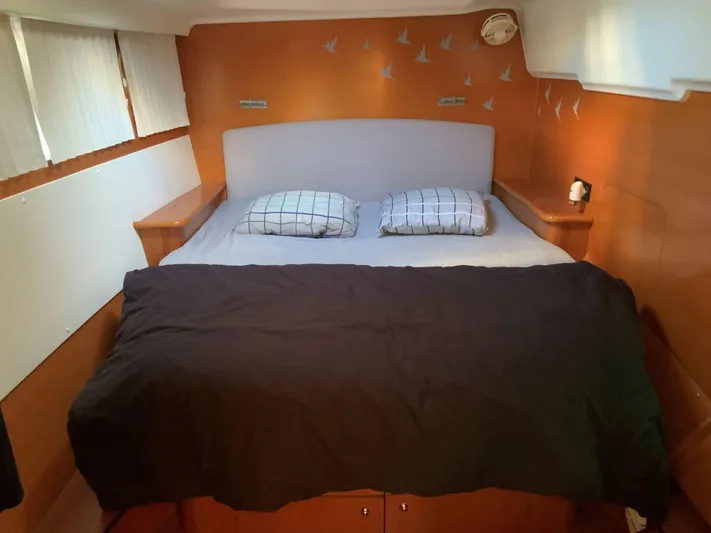  Yacht Photos Pics Cozy cabin interior of 2007 Lagoon 440 catamaran with double bed and decorative wall art.