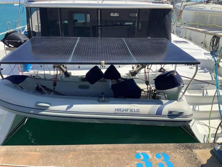  Yacht Photos Pics 2007 Lagoon 440 catamaran with solar panels and Highfield dinghy at dock.