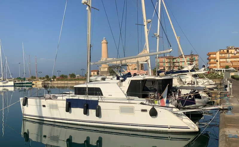  Yacht Photos Pics 2007 Lagoon 440 catamaran docked in a marina, with clear blue sky and lighthouse in background.