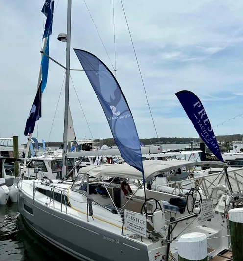 Show Boat! Special Pricing Yacht Photos Pics 2024 Beneteau Oceanis 37.1 sailboat docked at marina with flags.
