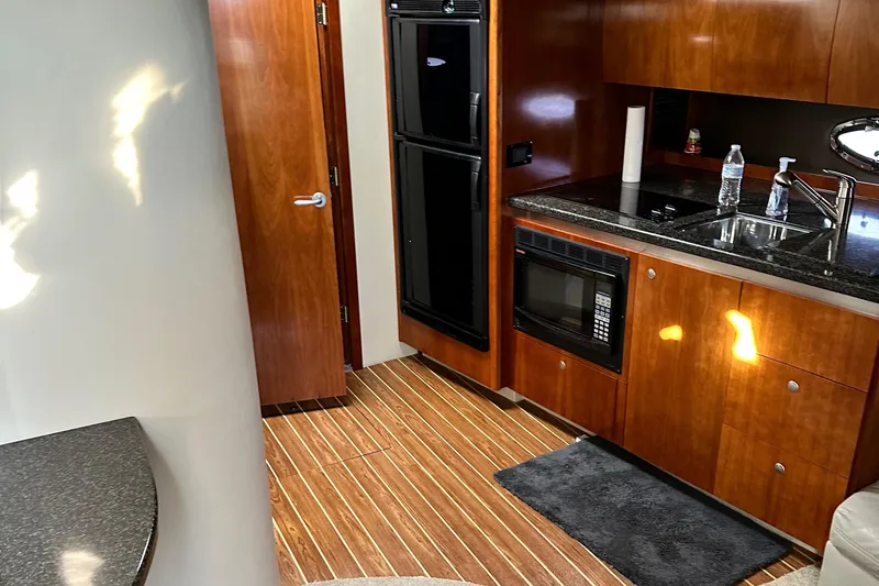 Majestic Yacht Photos Pics Interior of 2006 Cruisers Yachts 420 Express with wood cabinetry and modern kitchen amenities.