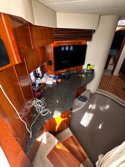 Majestic Yacht Photos Pics 2006 Cruisers Yachts 420 Express interior with TV, wooden cabinetry, and carpeted flooring.