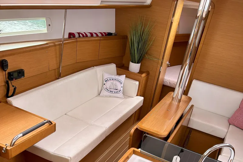 Patience Yacht Photos Pics Interior of 2012 Jeanneau Sun Odyssey 379 sailboat with white seating and wooden accents.