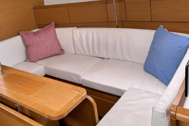 Patience Yacht Photos Pics Interior of 2012 Jeanneau Sun Odyssey 379 with white cushions and colorful pillows.