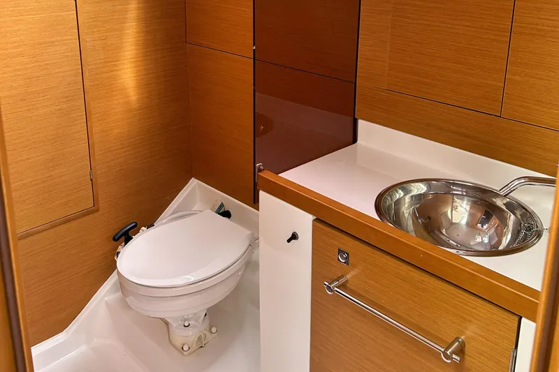 Patience Yacht Photos Pics 2012 Jeanneau Sun Odyssey 379 yacht bathroom with wooden cabinetry and stainless steel sink.