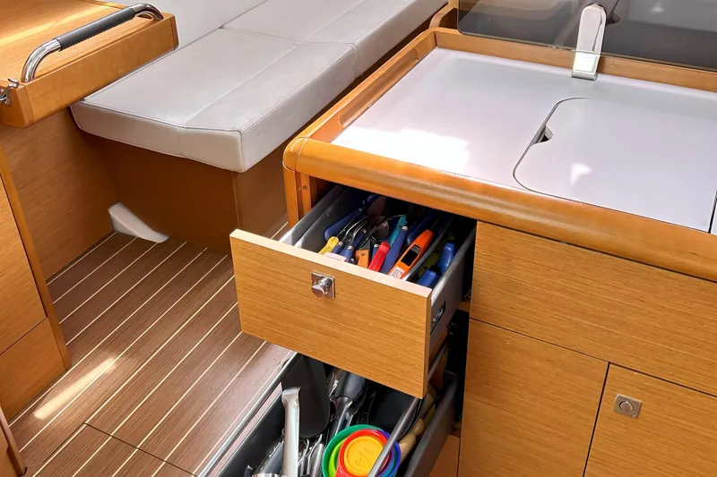 Patience Yacht Photos Pics Interior of 2012 Jeanneau Sun Odyssey 379 yacht with open drawer and seating area.
