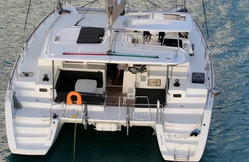 Blue Osprey Yacht Photos Pics 2020 Lagoon 450S catamaran on water, rear view, showcasing deck and seating area.