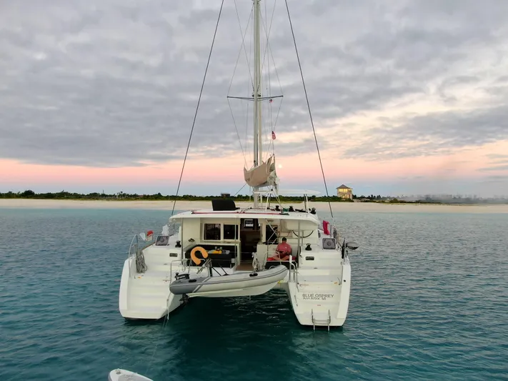 Blue Osprey Yacht Photos Pics Lagoon 450S catamaran anchored near a serene beach at sunset, 2020 model.