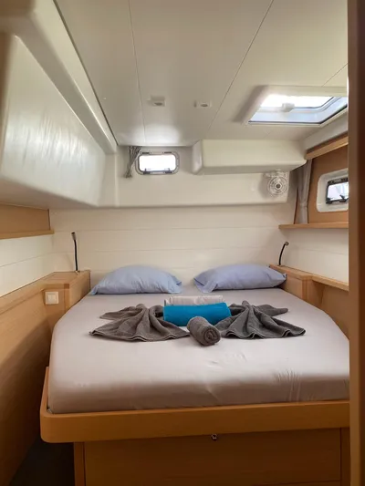 Blue Osprey Yacht Photos Pics Cozy cabin interior of 2020 Lagoon 450S with neatly arranged bed and porthole windows.