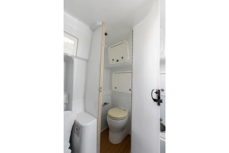 Yacht Photos Pics 2018 Yellowfin 42 Offshore boat bathroom interior with toilet and storage compartments.