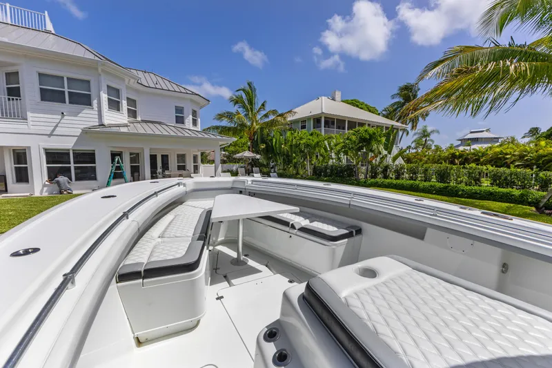  Yacht Photos Pics 2018 Yellowfin 42 Offshore boat docked near a luxurious waterfront home.