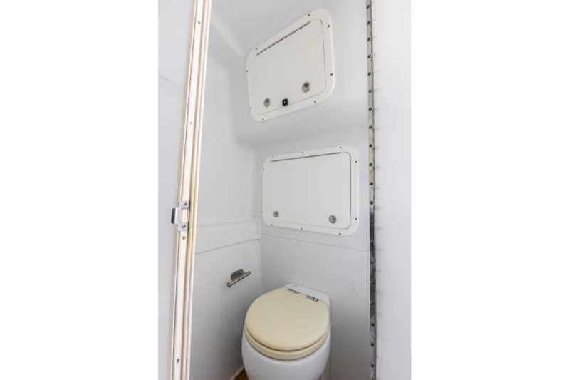  Yacht Photos Pics 2018 Yellowfin 42 Offshore boat bathroom with white toilet and storage compartments.