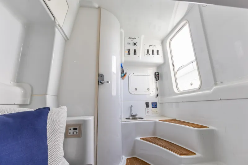  Yacht Photos Pics 2018 Yellowfin 42 Offshore cabin interior with control panels and wooden steps.