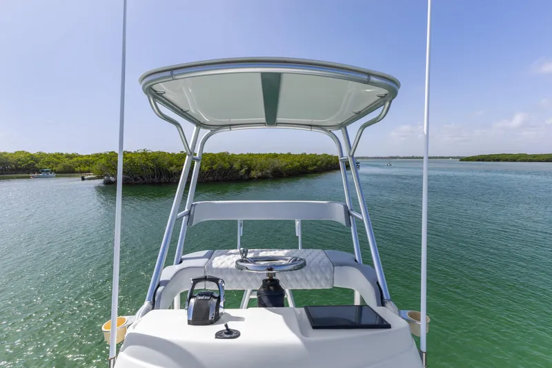  Yacht Photos Pics 2018 Yellowfin 42 Offshore boat navigating serene waters with lush green shoreline.
