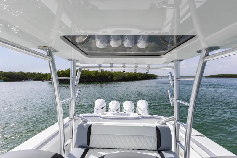  Yacht Photos Pics 2018 Yellowfin 42 Offshore boat with triple engines on a serene waterway.