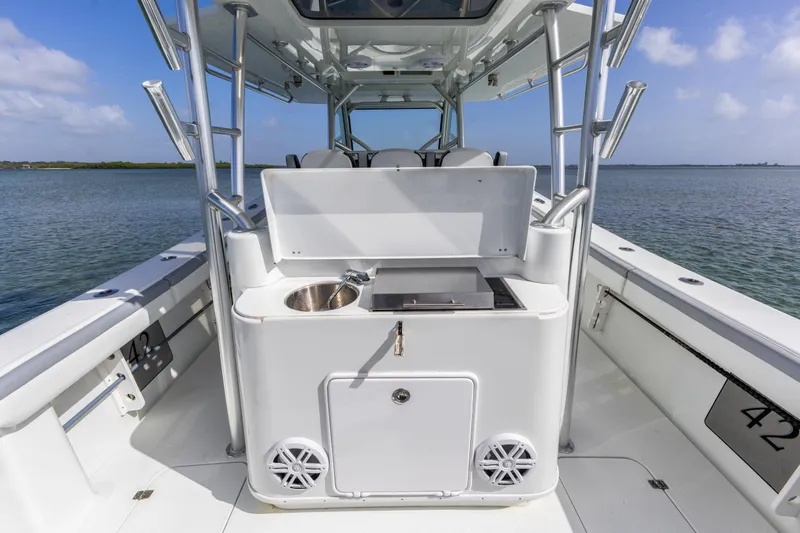  Yacht Photos Pics 2018 Yellowfin 42 Offshore boat with onboard sink and grill, set against a serene water backdrop.