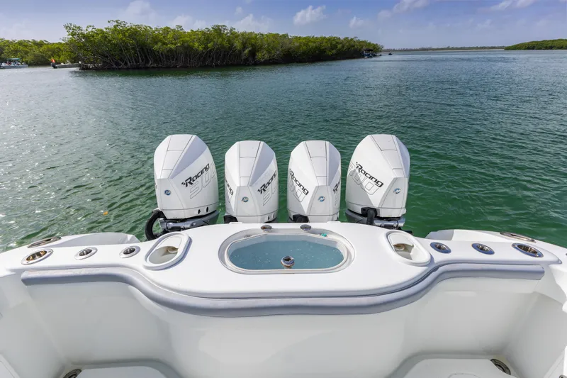  Yacht Photos Pics 2018 Yellowfin 42 Offshore boat with four powerful outboard engines on a serene waterway.