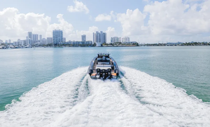 Heavy D Yacht Photos Pics 2023 Pirelli Tecnorib 50 speeding on water with city skyline in background.