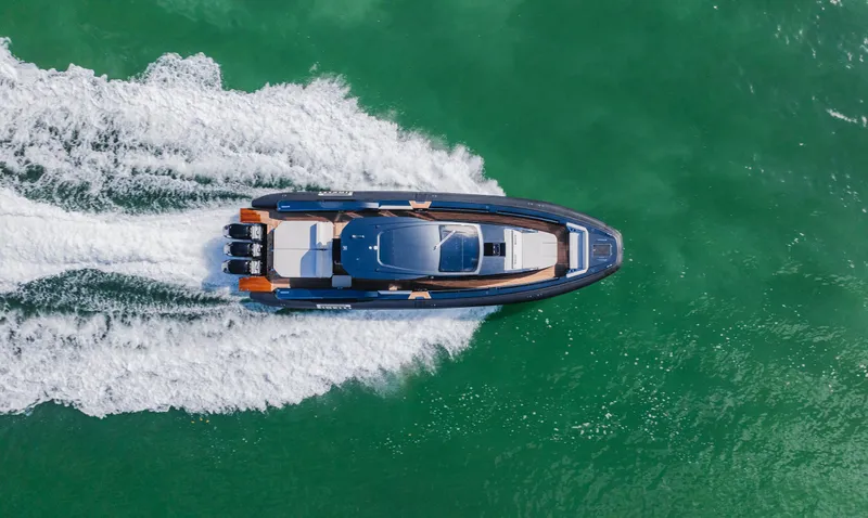 Heavy D Yacht Photos Pics 2023 Pirelli Tecnorib 50 speedboat cruising on vibrant green water, aerial view.