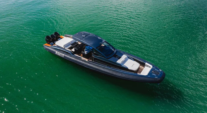 Heavy D Yacht Photos Pics 2023 Pirelli Tecnorib 50 luxury boat on clear green water.