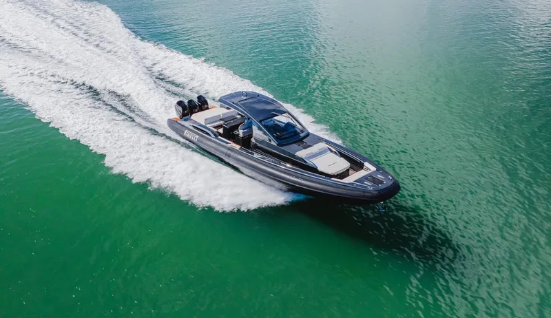 Heavy D Yacht Photos Pics 2023 Pirelli Tecnorib 50 speedboat cruising on clear green water.