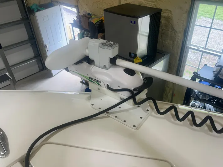  Yacht Photos Pics 2022 Contender 39 ST boat with a mounted trolling motor in a garage setting.