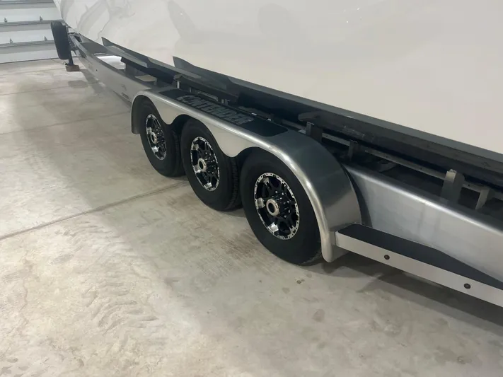  Yacht Photos Pics Trailer for 2022 Contender 39 ST boat with triple axles in a garage setting.