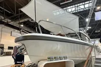 2022 Nimbus C8 boat displayed indoors with canopy and promotional materials.