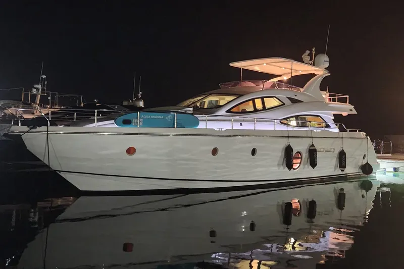  Yacht Photos Pics Luxurious 2009 Aicon 64 yacht docked at night, reflecting on calm water.
