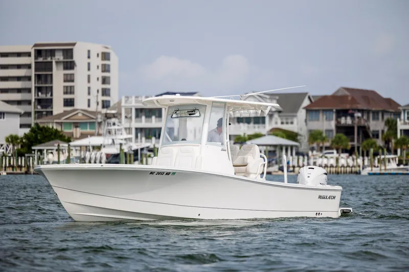  Yacht Photos Pics 2024 Regulator 26XO boat cruising near waterfront homes.