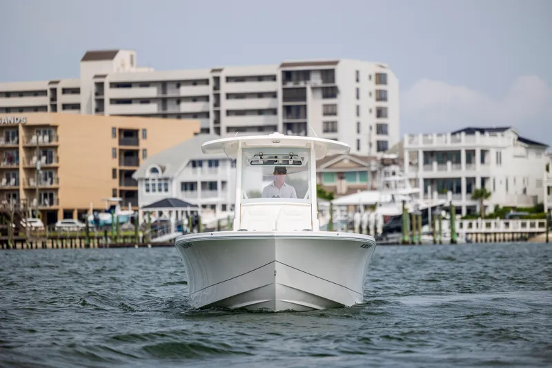  Yacht Photos Pics 2024 Regulator 26XO boat cruising near waterfront buildings.