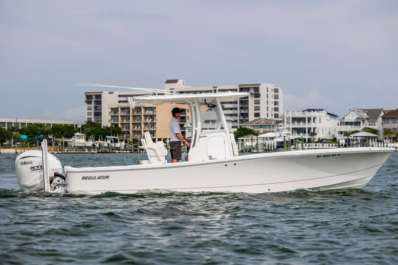  Yacht Photos Pics 2024 Regulator 26XO boat cruising near waterfront buildings.