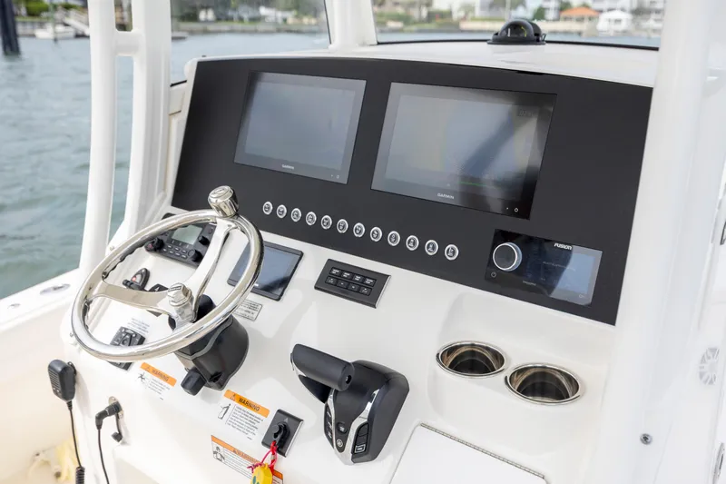  Yacht Photos Pics 2024 Regulator 26XO boat dashboard with steering wheel, dual screens, and control panel.