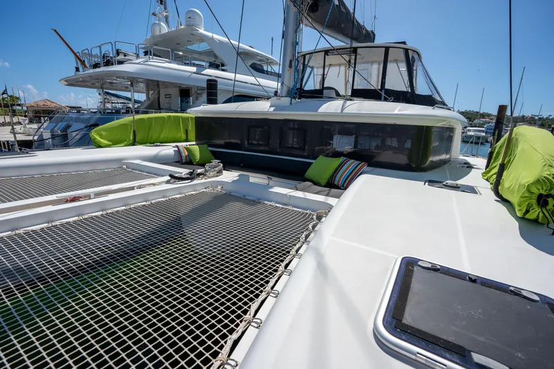  Yacht Photos Pics 2019 Lagoon 450 F catamaran with netted deck and colorful cushions in a marina.