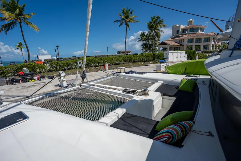  Yacht Photos Pics 2019 Lagoon 450 F catamaran docked, featuring spacious deck with colorful cushions and tropical backdrop.