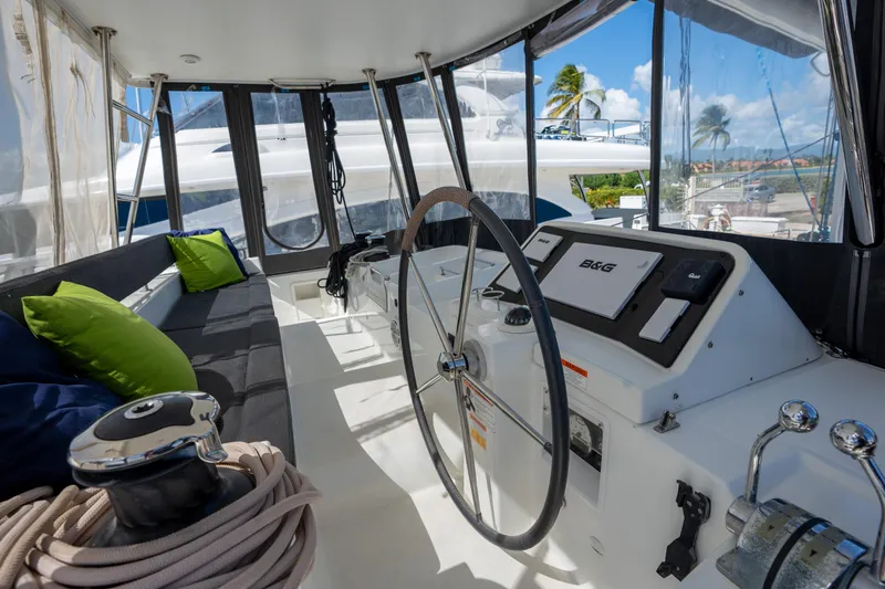  Yacht Photos Pics 2019 Lagoon 450 F yacht cockpit with steering wheel, seating, and navigation equipment.