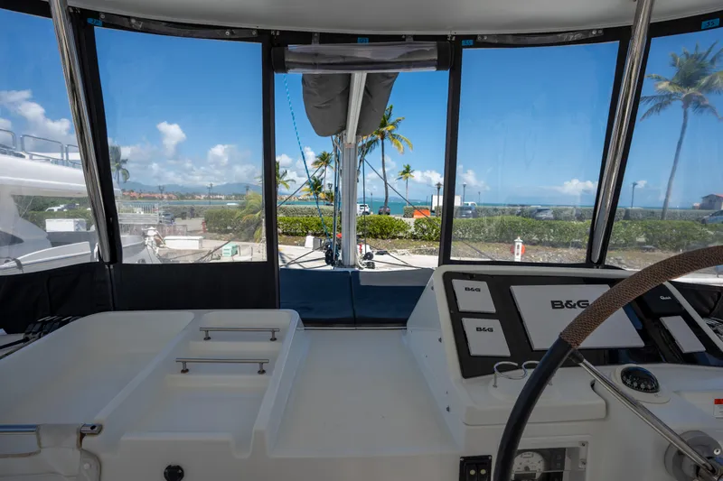  Yacht Photos Pics Interior view of 2019 Lagoon 450 F yacht cockpit with ocean and palm trees visible.