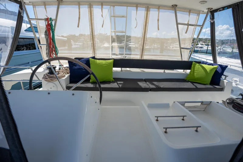  Yacht Photos Pics 2019 Lagoon 450 F yacht cockpit with seating, steering wheel, and vibrant green cushions.