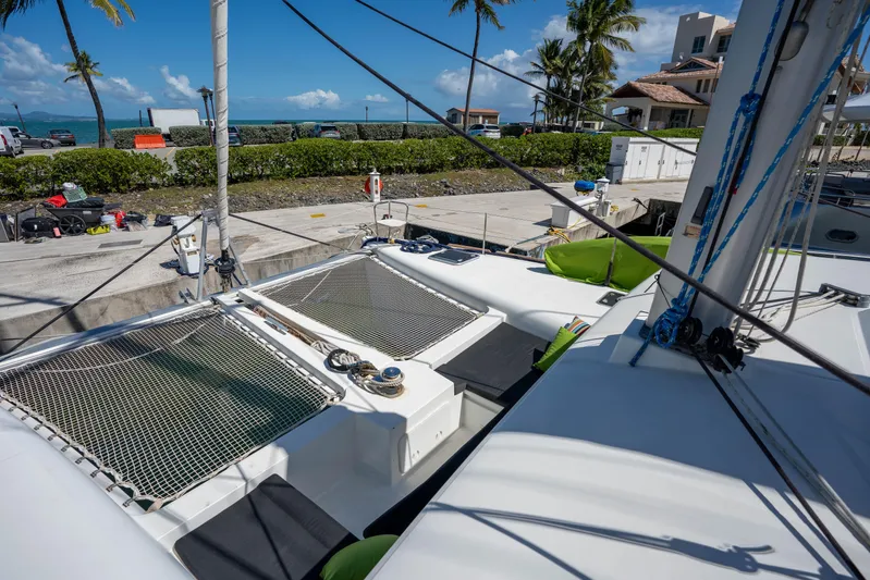  Yacht Photos Pics 2019 Lagoon 450 F catamaran docked, featuring netted deck and tropical background.