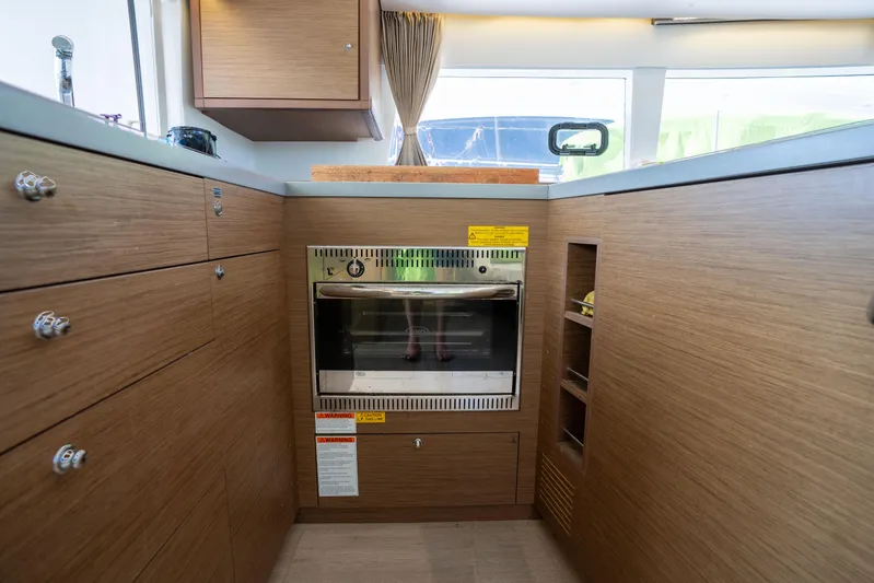  Yacht Photos Pics Modern kitchen interior of 2019 Lagoon 450 F yacht with wood cabinetry and built-in oven.