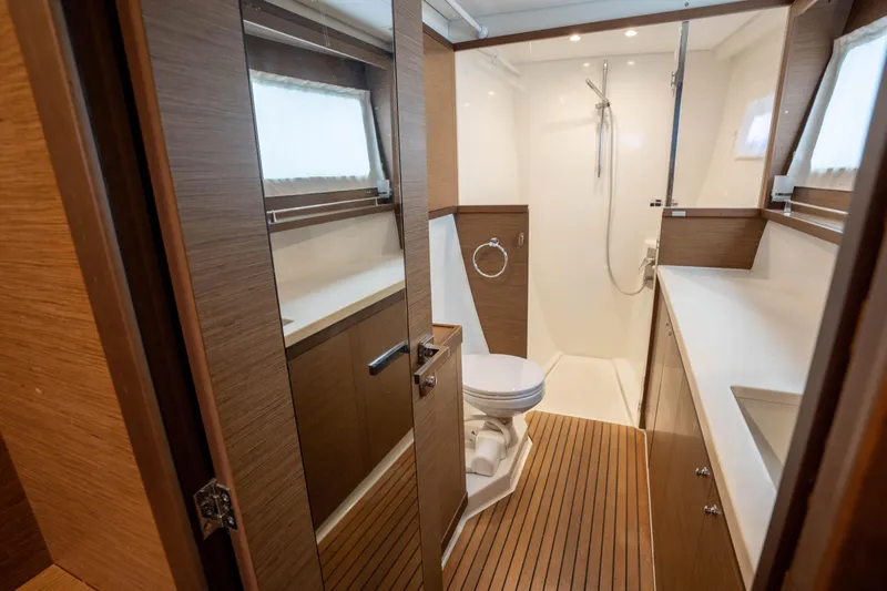  Yacht Photos Pics Luxurious bathroom in 2019 Lagoon 450 F yacht with wooden accents and modern fixtures.