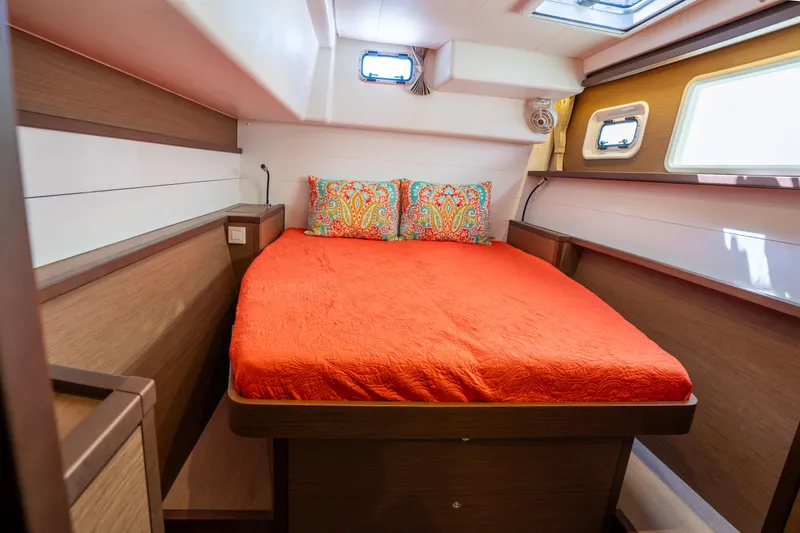  Yacht Photos Pics Cozy cabin interior of 2019 Lagoon 450 F catamaran with vibrant orange bedding.
