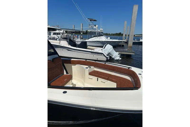  Yacht Photos Pics 2025 Scout 277 LXF boat docked, featuring luxurious seating and sleek design.